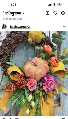 an image of a wreath with flowers and pumpkins on the front door for halloween