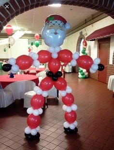 an inflatable santa clause balloon standing on top of a floor next to a table