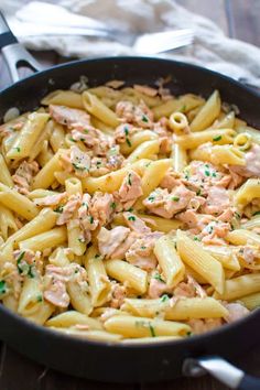 a skillet filled with pasta covered in tuna