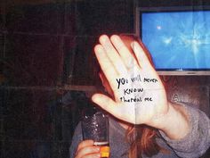 a woman holding up her hand with writing on it