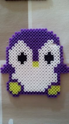 a purple and white beaded penguin with black eyes