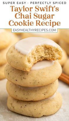 a stack of cookies with white frosting on top and cinnamon sticks in the background