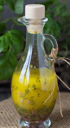 a pitcher filled with liquid sitting on top of a table next to a potted plant