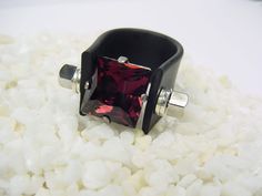 Rubber ring with Austrian crystal in burgundy color / 12 x 12 mm square. The bar of the wide band is made of stainless steel. This ring is noted. An absolute highlight for your next event. The ring band is made of soft black rubber. Very comfortable to wear. The rail with cubes and roundels is made of stainless steel. This elaborate statement ring / cocktail ring is set with a sparkling Austrian crystal in the color burgundy / wine red. The ring sizes have a tolerance in diameter due to the feel Modern Rectangular Jewelry For Party, Luxury Red Party Rings, Red Square Cut Jewelry For Formal Occasions, Formal Red Square Cut Jewelry, Formal Red Square-cut Jewelry, Adjustable Burgundy Jewelry For Party, Rectangular Red Jewelry For Evening, Red Rectangular Jewelry For Evening, Elegant Red Square Jewelry