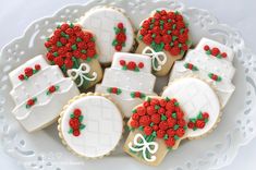 decorated cookies on a white plate with bows and red roses in the top one cookie