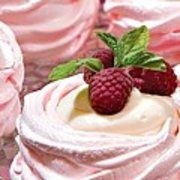 some very pretty pink cupcakes with white frosting and raspberries on top