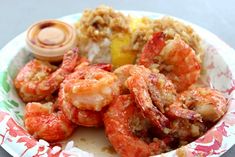 a paper plate with shrimp and rice on it