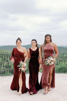 three bridesmaids pose for a photo in front of the view at their wedding