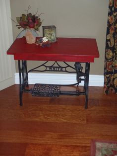 a red table sitting in the corner of a room