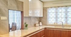 a kitchen with white counter tops and wooden cabinets