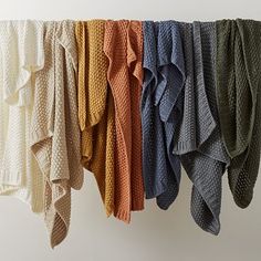 a row of sweaters hanging on a clothes line with one folded over the top