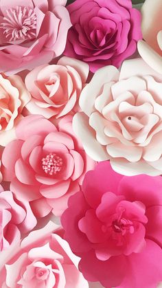 pink and white paper flowers are arranged together