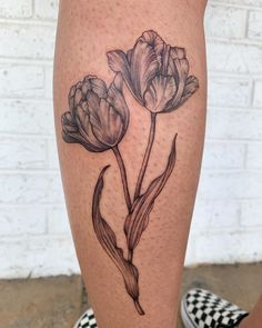 a woman's leg with flowers tattooed on it