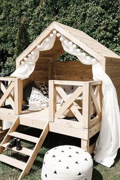 a wooden bed in the shape of a house with stairs leading up to it's roof