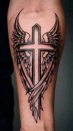 a cross and wings tattoo on the leg