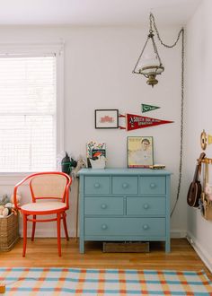 a blue dresser sitting next to a window in a room