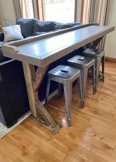 the table is made out of wood and has three stools underneath it, along with a couch