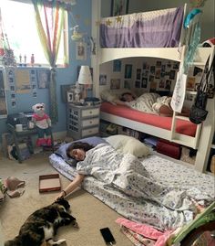 a person laying in bed with a dog on the floor next to them and a child sleeping