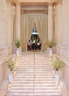 the entrance to an elegantly decorated building with flowers and candles in vases on the steps