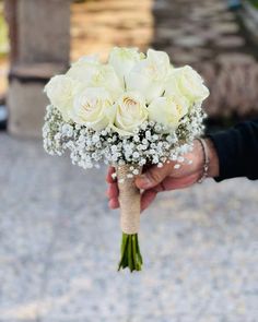 a person holding a bouquet of white flowers