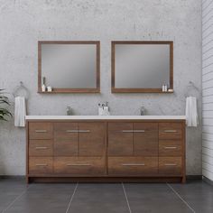 a bathroom with two sinks and mirrors on the wall next to a potted plant