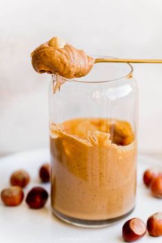 a spoonful of peanut butter in a glass jar