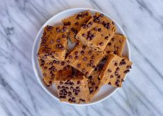 a white plate topped with chocolate chip toffes on top of a marble counter