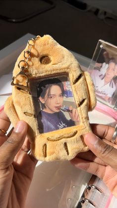 a person holding up a small stuffed animal with a photo in it's frame