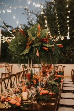 the table is set with candles, flowers and greenery for an outdoor wedding reception