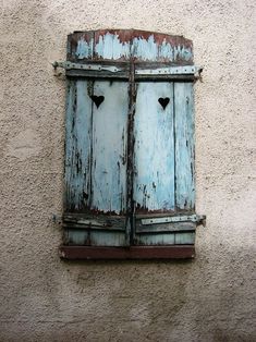 an old wooden window with two heart shaped windows