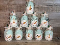 there are many snowmen painted on mason jars