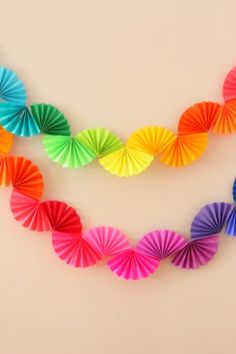 multicolored paper fan garland hanging on the wall