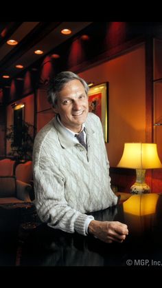 a man sitting at a table in front of a lamp