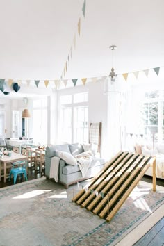 a living room filled with lots of furniture next to a dining table and couches