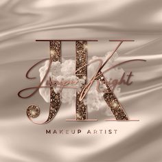 the logo for j k makeup artist, with gold glitters and white fabric in the background