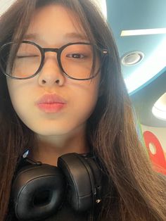 a woman with glasses and headphones on