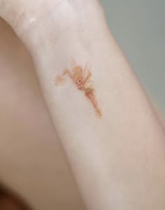 a woman with a small tattoo on her arm and wrist is looking at the camera