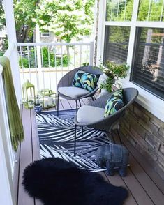 a porch with chairs and rugs on it