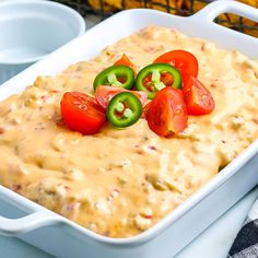 a casserole dish with tomatoes, jalapenos and cheese on top