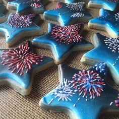 blue decorated cookies with red, white and blue sprinkles are on a table