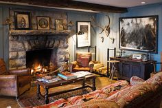 a living room filled with furniture and a fire place in front of a stone fireplace