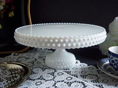 a white cake plate sitting on top of a table