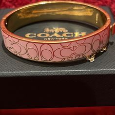 Coach Signature Pink Enamel Bracelet With Box J-21 Beautiful Light Pink And Gold Enamel Cuff Bangle Bracelet With Safety Chain. Classic Coach "C" Design All Over. Such A Lovely Addition To Any Sophisticated Ladies Jewelry Collection. Take Her Home Today! Box Is Included! **More Information Including Measurement Coming Soon!** Thank You For Shopping My Closet. G.41 Coach Bracelets As Gift, Luxury Adjustable Bracelet By Coach, Luxury Adjustable Coach Bracelets, Luxury Adjustable Coach Bracelet, Luxury Adjustable Coach Jewelry, Coach Bangle Bracelets Gift, Classic Coach Jewelry For Gifts, Coach Classic Bangle Jewelry, Classic Coach Bangle Jewelry