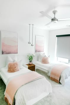 two beds in a bedroom with pink and white decor