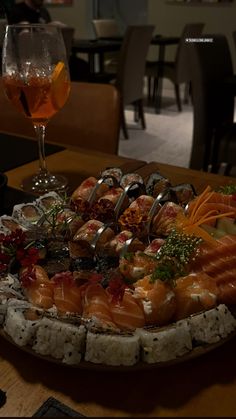 a platter of sushi and wine on a table