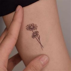 a woman's arm with a flower tattoo on the left side of her body