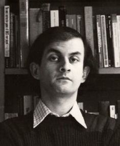 a man standing in front of a bookshelf