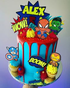 a spiderman themed birthday cake with cupcakes and decorations on the top tier