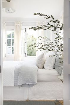 a bedroom with white bedding and pillows