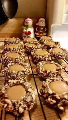 several cookies are cooling on a rack with peanut butter and jelly in the middle, next to a santa clause figurine